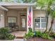 Welcoming front porch with tile floor, seating and colorful plantings, plus an American flag waving at 1701 Lucky Pennie Way, Apopka, FL 32712
