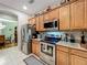 Functional kitchen featuring stainless steel appliances and wooden cabinets for plenty of storage at 1701 Lucky Pennie Way, Apopka, FL 32712