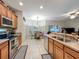 Open kitchen with stainless steel appliances, wood cabinets, and a view of the dining area at 1701 Lucky Pennie Way, Apopka, FL 32712
