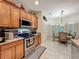 Well-lit kitchen with wood cabinets, stainless steel appliances, and tile floors at 1701 Lucky Pennie Way, Apopka, FL 32712