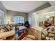 Inviting living room featuring comfortable seating, hardwood floors, a large window, and an open view into the dining area at 1701 Lucky Pennie Way, Apopka, FL 32712