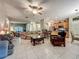 Spacious living room featuring neutral tones and tile flooring, adjacent to kitchen with breakfast bar at 1701 Lucky Pennie Way, Apopka, FL 32712