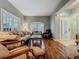 Well-lit living room featuring a sofa, decorative chairs, hardwood floors, and a large window with shutters at 1701 Lucky Pennie Way, Apopka, FL 32712