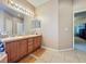 Bathroom showcasing dual sinks with a large mirror and vanity lights, along with access to the main bedroom at 1701 Lucky Pennie Way, Apopka, FL 32712