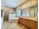 Bright bathroom featuring a soaking tub, a glass-enclosed shower, and a dual sink vanity at 1701 Lucky Pennie Way, Apopka, FL 32712