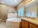 Bright bathroom featuring a soaking tub, a glass-enclosed shower, and a vanity sink at 1701 Lucky Pennie Way, Apopka, FL 32712