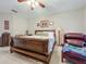 Spacious main bedroom featuring a ceiling fan, neutral walls, and an inviting armchair for relaxation at 1701 Lucky Pennie Way, Apopka, FL 32712