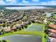 A wide-angle aerial photograph of the community highlighting a pond with lush green surroundings at 172 Verde Way, Debary, FL 32713