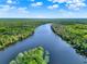 An aerial view of a river surrounded by lush green trees on a sunny day with blue skies at 172 Verde Way, Debary, FL 32713