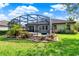 Well-maintained backyard with a screened-in patio, complete with a hot tub and tropical landscaping at 172 Verde Way, Debary, FL 32713