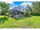 Lush backyard featuring a screened patio, hot tub, and tranquil water views at 172 Verde Way, Debary, FL 32713