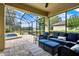 Relaxing screened patio with comfortable wicker furniture and a view of the lake at 172 Verde Way, Debary, FL 32713