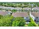 This aerial view shows a townhome community with lots of green trees, and a marker indicating a property location at 17441 Hidden Forest Dr, Clermont, FL 34714