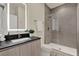 Stylish bathroom featuring a single sink vanity, illuminated mirror, and a glass-enclosed shower at 17441 Hidden Forest Dr, Clermont, FL 34714