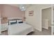 This bedroom has pink walls, a queen bed with white bedding, matching nightstands, and an interesting light fixture at 17441 Hidden Forest Dr, Clermont, FL 34714
