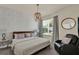 Relaxing bedroom with a comfortable bed, decorative wall art, and a cozy armchair at 17441 Hidden Forest Dr, Clermont, FL 34714