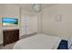 This is a bedroom featuring a queen bed, a wood dresser, white walls, and a modern light fixture at 17441 Hidden Forest Dr, Clermont, FL 34714