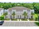 This is a townhome with white walls, a grey roof, palm trees, and decorative stone around the front doors at 17441 Hidden Forest Dr, Clermont, FL 34714