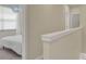 Hallway view of a bedroom with window and another bedroom with a door on the second floor at 17441 Hidden Forest Dr, Clermont, FL 34714