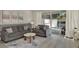 Comfortable living room with gray sofas, accent pillows, and sliding glass doors to the pool area at 17441 Hidden Forest Dr, Clermont, FL 34714