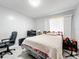 Cozy bedroom with a patterned quilt and a bright window at 1826 W Silver Springs Blvd, Ocala, FL 34475