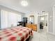 Well-lit bedroom with a large window, tiled floor, and a wooden dresser at 1826 W Silver Springs Blvd, Ocala, FL 34475