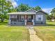 Charming single-story home featuring a cozy screened-in porch and a vibrant red front door at 1826 W Silver Springs Blvd, Ocala, FL 34475