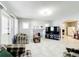 Bright living room featuring neutral tile flooring, gray painted fireplace, and open layout at 1826 W Silver Springs Blvd, Ocala, FL 34475
