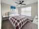 Cozy bedroom with plaid bedding, ceiling fan, and natural light from the large window at 224 Hammock Dunes Pl, Orlando, FL 32828