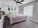 Bedroom featuring a bed with decorative pillows, side tables, art, a ceiling fan, and a window at 224 Hammock Dunes Pl, Orlando, FL 32828