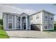 Spacious two-story home with an elegant grey exterior, large windows, and a patterned brick driveway at 224 Hammock Dunes Pl, Orlando, FL 32828