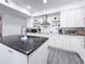 Modern kitchen with white cabinetry, marble backsplash, updated appliances, and a black island at 224 Hammock Dunes Pl, Orlando, FL 32828
