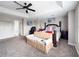 Bright primary bedroom featuring tray ceilings, ceiling fan, sitting area, and ensuite entrance at 224 Hammock Dunes Pl, Orlando, FL 32828