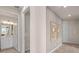 Hallway with light grey wood paneling, decorative wall hangings, and an open view of the bathroom at 2334 Daisy Tree Rd, St Cloud, FL 34771
