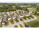 An aerial view of a neighborhood featuring neatly lined homes with solar panels and tree-lined streets at 2417 Liner Ave, Apopka, FL 32703