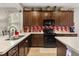Spacious kitchen featuring dark cabinets, stylish backsplash, and black appliances, creating a modern cooking space at 2417 Liner Ave, Apopka, FL 32703
