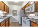 Compact kitchen features white appliances, wood cabinetry, and granite countertops at 2500 Lee Rd # 243, Winter Park, FL 32789