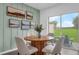 A sunlit dining area features a round wooden table, seating for four, and a view of the green backyard at 3345 Thicket St, Tavares, FL 32778