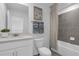 Modern bathroom with sleek gray tiled shower and tub, a white vanity, and stylish fixtures at 3348 Thicket St, Tavares, FL 32778
