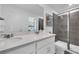 Elegant bathroom features double sinks with quartz countertops and glass-enclosed shower at 3348 Thicket St, Tavares, FL 32778