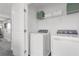 Convenient laundry room with a washer, dryer, and storage shelving at 3348 Thicket St, Tavares, FL 32778