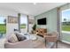 Cozy living room with a plush sofa, decorative pillows, and large windows overlooking the yard at 3348 Thicket St, Tavares, FL 32778