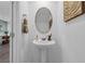Stylish powder room featuring a pedestal sink, oval mirror, and modern decor at 3348 Thicket St, Tavares, FL 32778