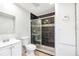 Modern bathroom with black tiled shower, glass door and vanity sink at 338 Eastern Ave, St Cloud, FL 34769