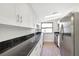 Bright kitchen featuring white cabinetry, black countertops and stainless steel appliances at 338 Eastern Ave, St Cloud, FL 34769