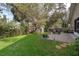 Spacious backyard with a brick patio area and mature landscaping providing shade at 39939 Parkinsonia St, Lady Lake, FL 32159