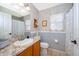 Well-lit bathroom with a decorative mirror, a window, and a traditional-style vanity at 39939 Parkinsonia St, Lady Lake, FL 32159