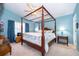 Charming bedroom featuring a four-poster bed, light blue walls, and a ceiling fan for added comfort at 39939 Parkinsonia St, Lady Lake, FL 32159