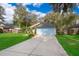 Charming single-story home with a light blue garage door and lush green lawn at 39939 Parkinsonia St, Lady Lake, FL 32159