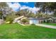 Beautifully landscaped single-story home with a blue garage door and a green front lawn at 39939 Parkinsonia St, Lady Lake, FL 32159